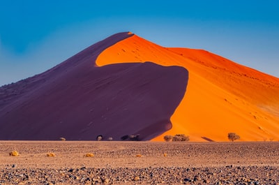 白天蓝天下的棕色沙丘